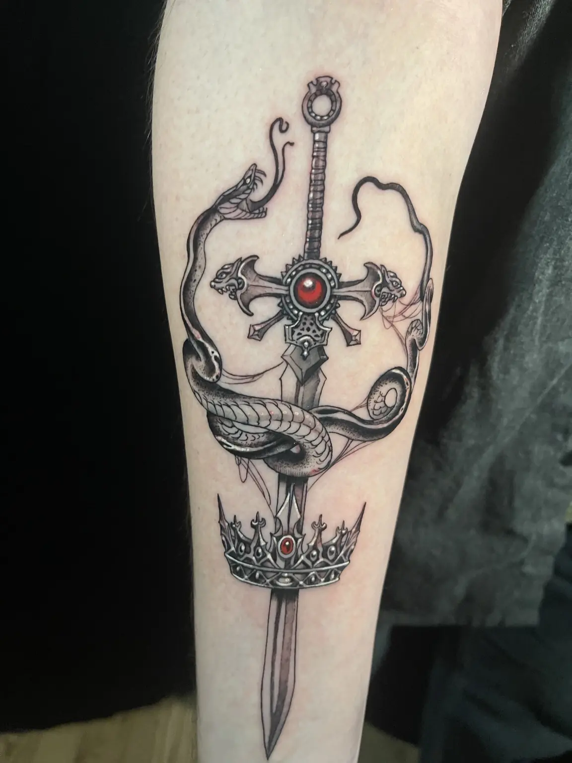 Black-and-gray fantasy sword and crown tattoo by Keith