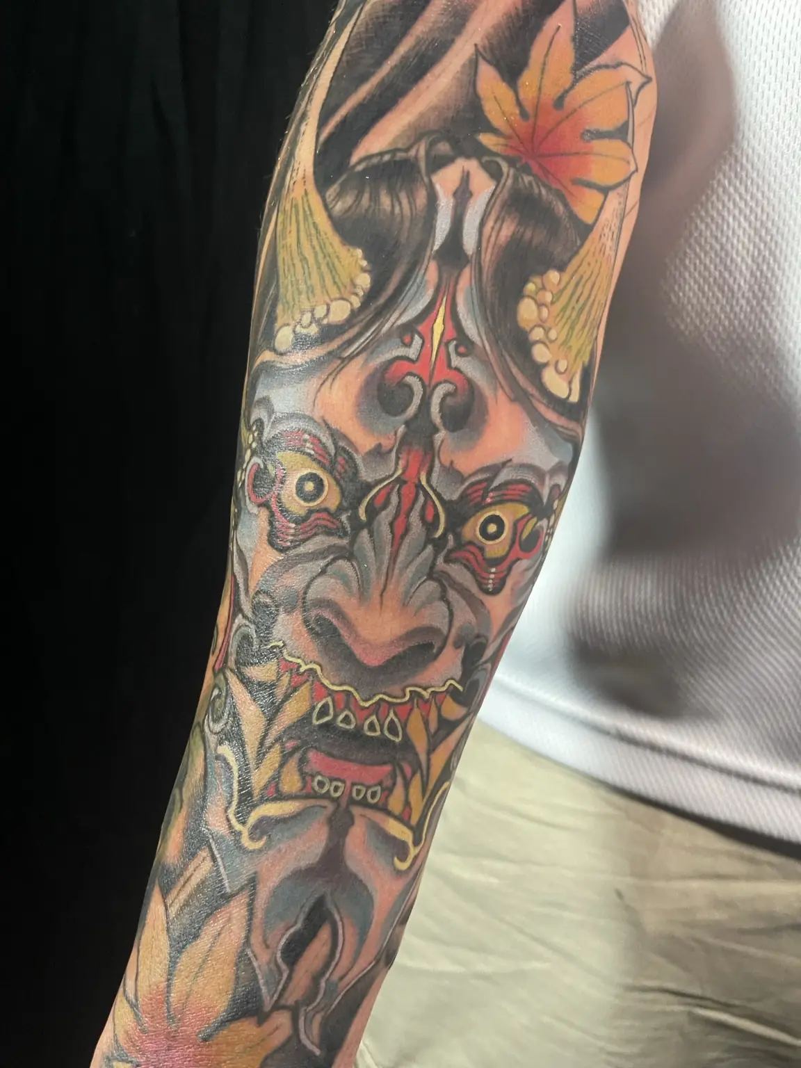 Full-color Japanese-inspired oni and maple leaf sleeve tattoo by Keith