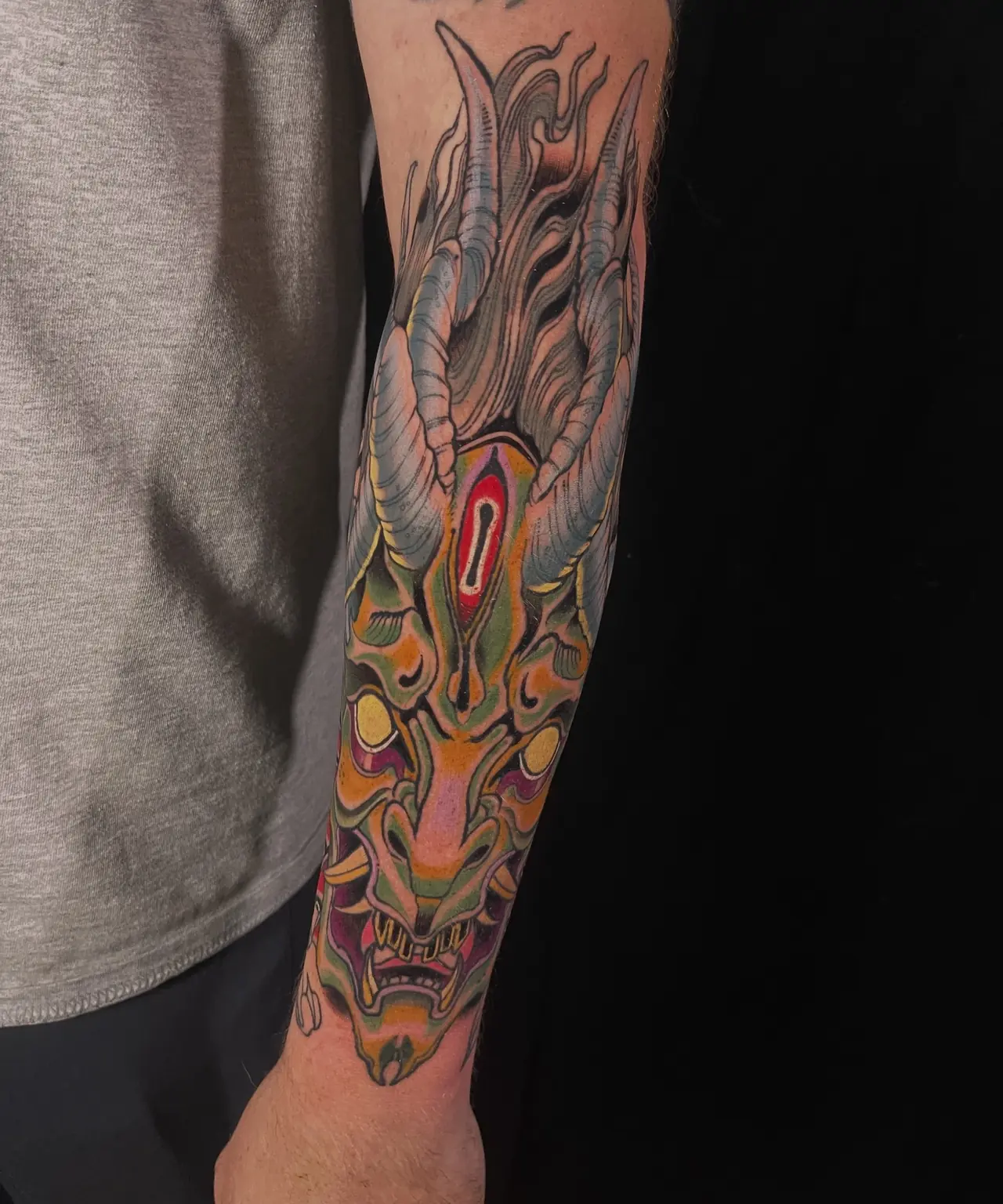 Full-color Japanese-inspired oni mask forearm tattoo by Keith