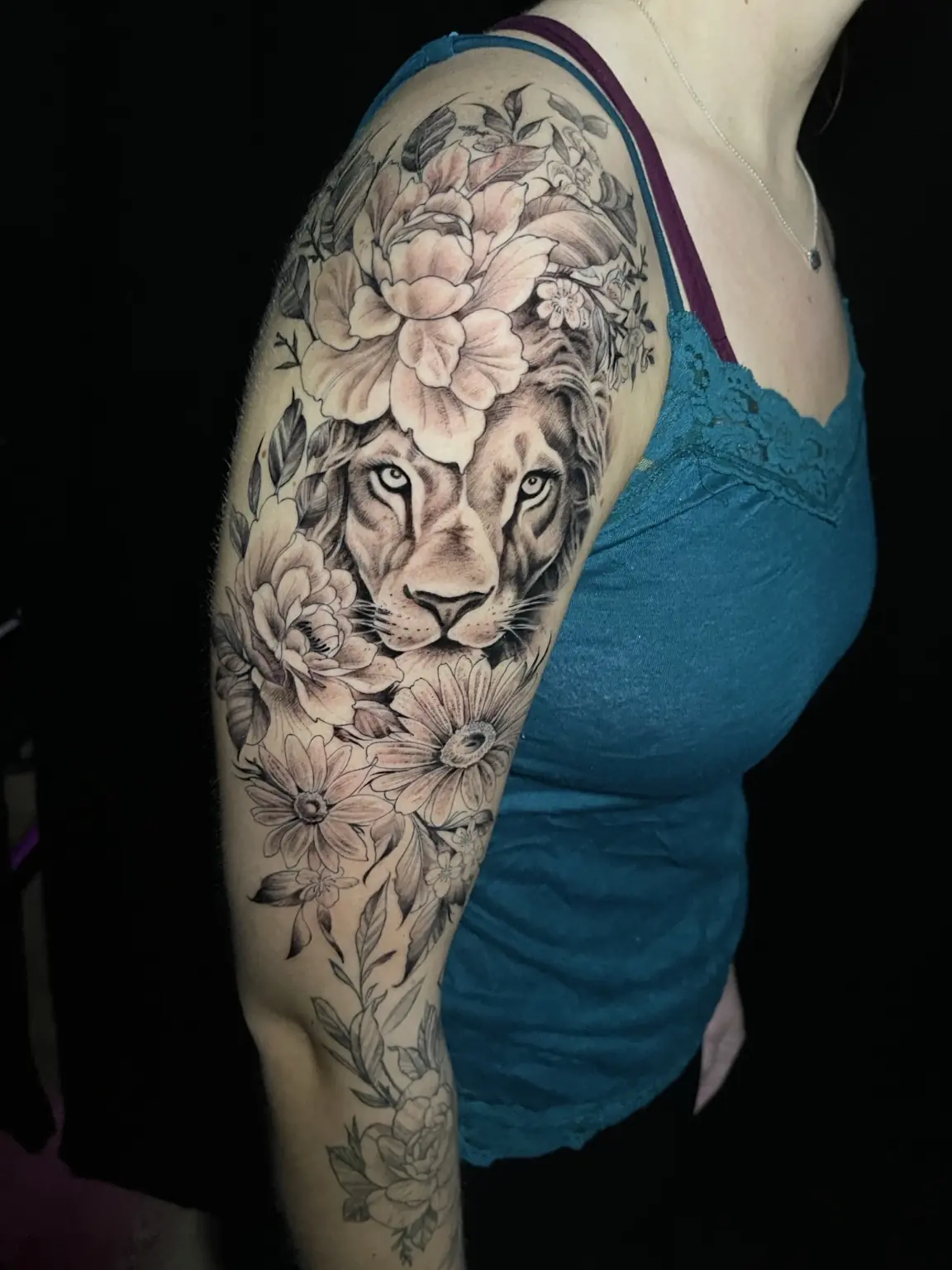 Black-and-gray lion and floral upper-arm tattoo by Keith