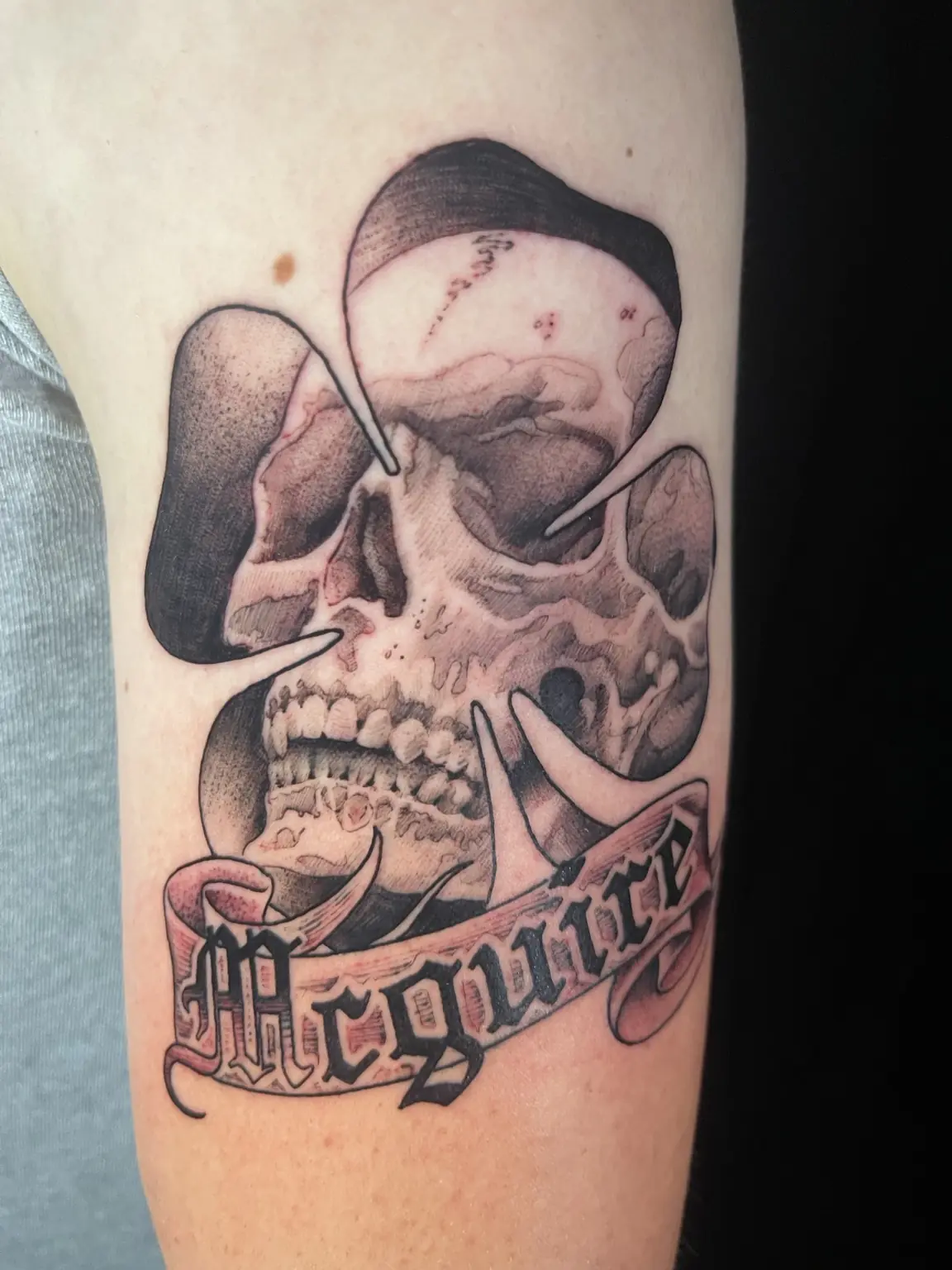 Black-and-gray skull and memorial banner tattoo by Keith
