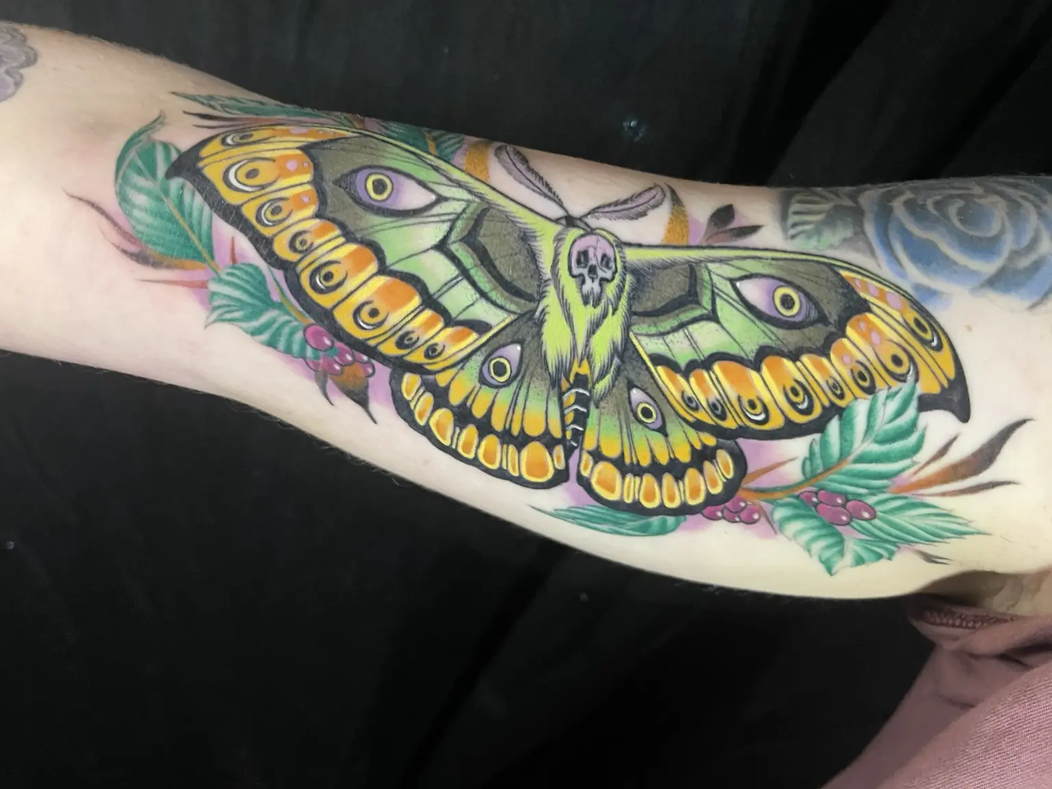 Full-color moth forearm tattoo by Keith