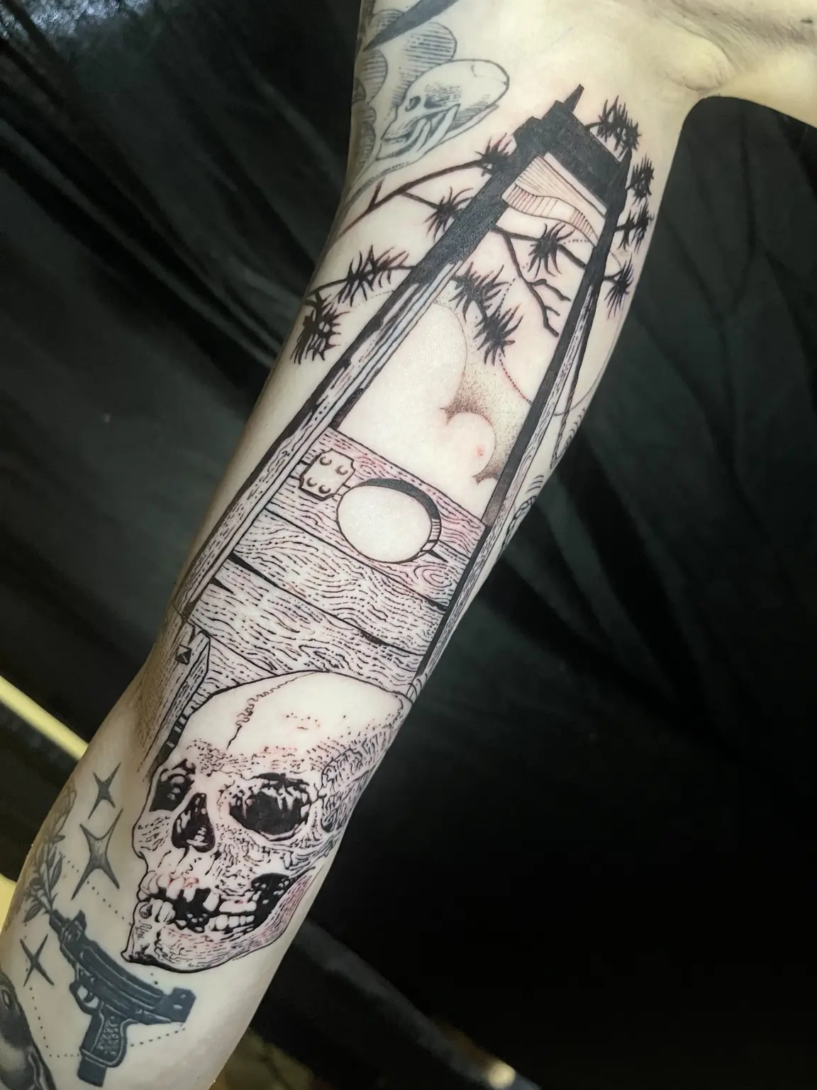 Black-and-gray tarot card and skull forearm tattoo by Keith